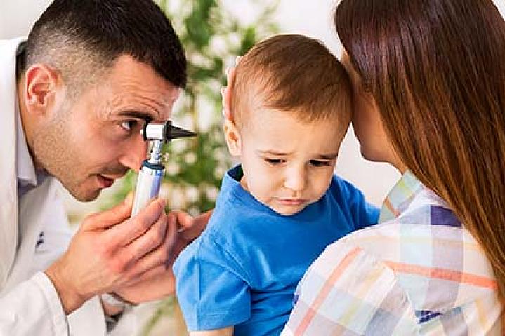 Doctor examining a child’s ear.