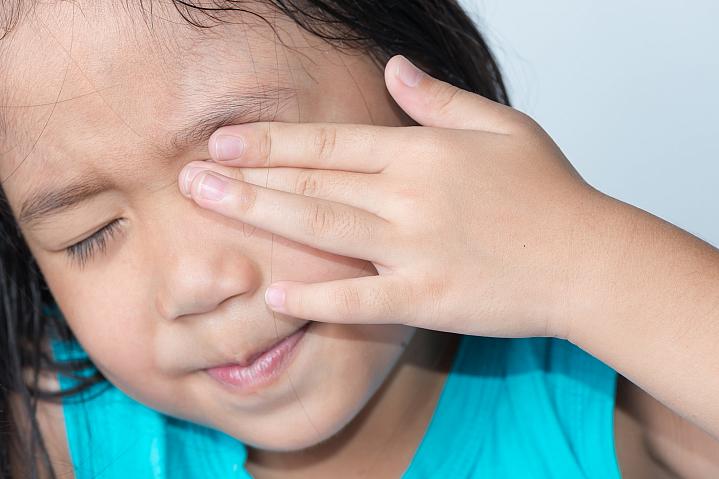 Young girl rubbing her eye