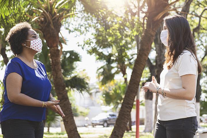 Two women talking outside with masks and social distancing