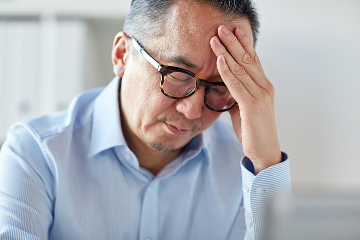 Man holding his hand on his forehead in pain